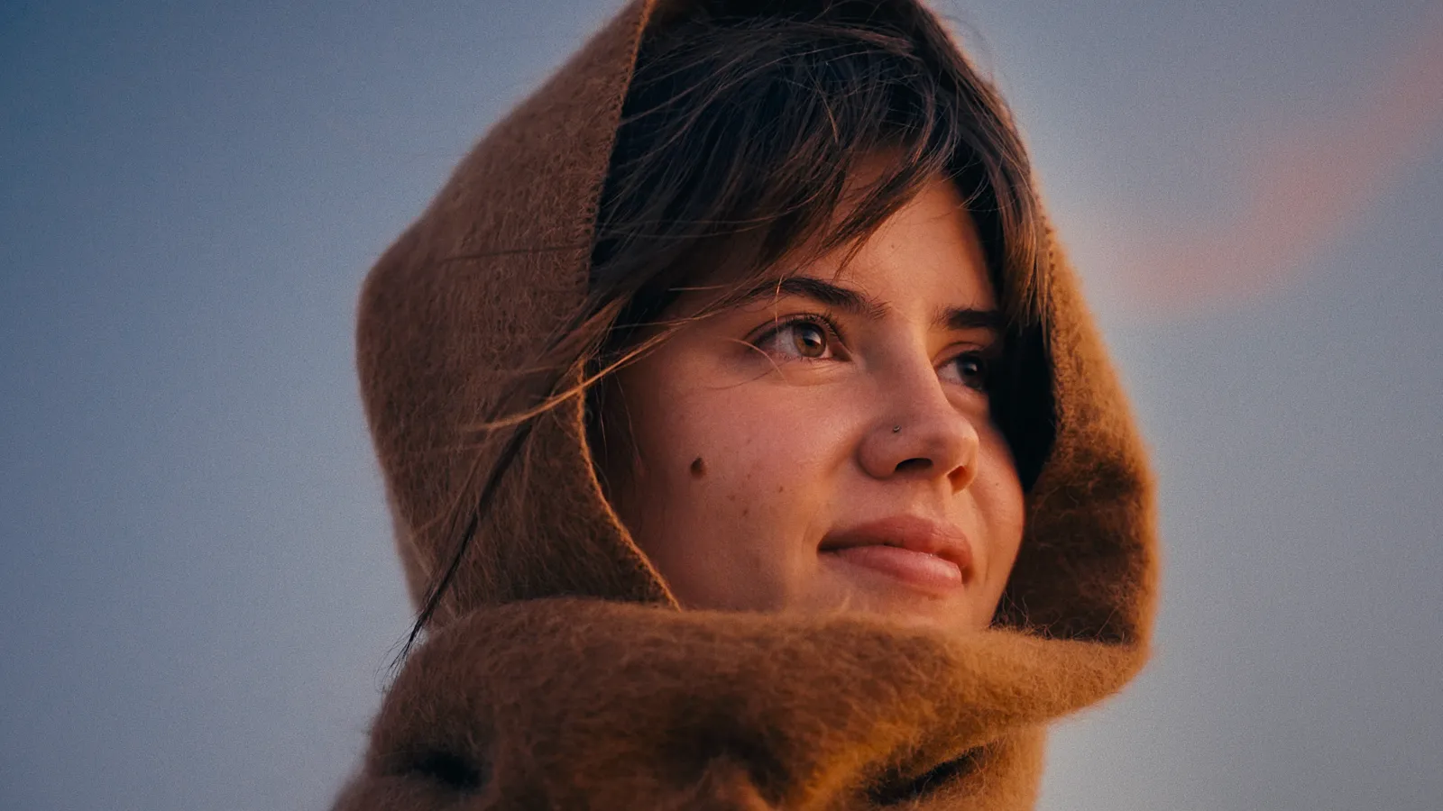 A woman wrapped in a scarf outdoors, graded with CineFilm